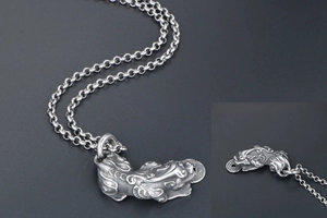Close-up of vintage titanium steel Pixiu pendant featuring intricate coin details