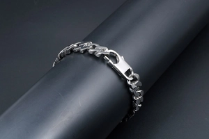 Dettaglio della catena a infinito in argento con chiusura a moschettone su base nera