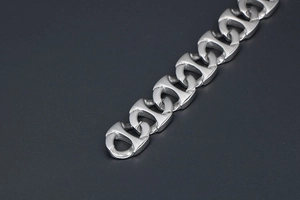 Détail macro d'une chaîne en acier titane argenté avec maillons nez de porc et texture brossée