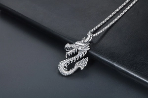 Vue détaillée du pendentif dragon en acier titane argenté avec écailles sur cuir noir