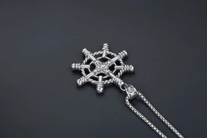 Macro detail of nautical helm pendant with vintage silver finish and thick chain