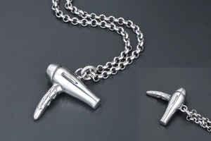Détail macro du pendentif sèche-cheveux argenté avec motifs gravés fins sur le manche