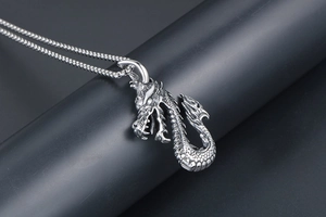 Vue détaillée du pendentif dragon argenté vintage avec écailles et chaîne boîte