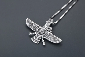 Macro detail of Faravahar pendant with fine wing texture on a stainless steel box chain
