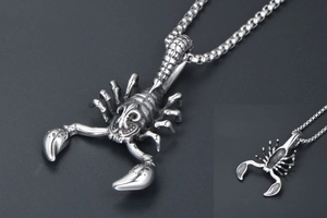Macro view of vintage silver scorpion pendant with intricate carving and back detail