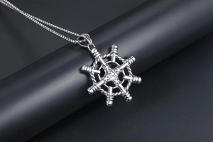 Macro shot of silver polished nautical helm pendant with detailed rope texture and steel chain