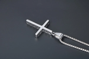Détail du pendentif croix religieuse en argent avec gravure relief et chaîne box maille