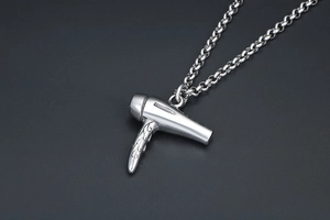 Détail macro d'un collier avec pendentif sèche-cheveux argenté poli et chaîne épaisse