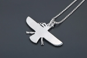 Macro shot of silver stainless steel Faravahar pendant on a classic box chain necklace