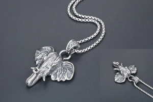 Detail of vintage titanium steel elephant pendant with intricate carvings and aged silver finish