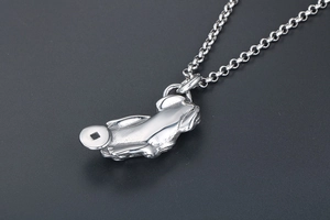 Macro detail of vintage silver Pixiu pendant with lucky coin on a classic cross chain