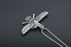 Detail of silver Faravahar pendant showing intricate wing textures on a long chain necklace