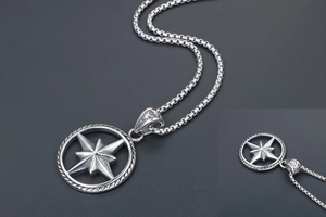 Macro detail of vintage silver compass pendant with box chain and octagonal star motif