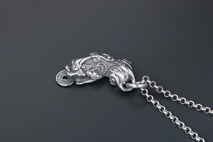 Macro detail of vintage titanium steel Pi Xiu pendant necklace with antique coin design