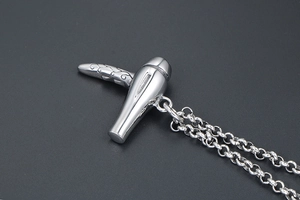 Gros plan du pendentif sèche-cheveux argenté avec gravures de vignes rétro sur le manche