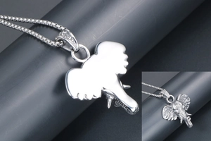 Macro shot of silver elephant head pendant featuring detailed carving and polished back