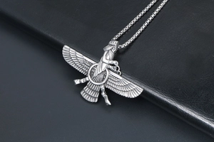 Macro view of Persian Faravahar necklace pendant with vintage silver wing details