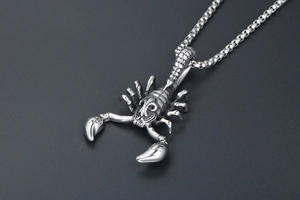 Macro shot of titanium steel scorpion pendant with vintage finish and box chain detail