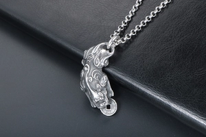 Macro shot of vintage titanium steel Pixiu pendant with detailed ancient coin textures