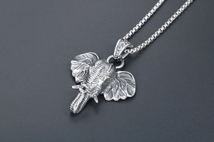 Detail of vintage silver elephant pendant with intricate skin texture and matching chain