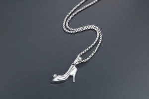 Close-up of a polished silver high heel pendant necklace on a modern box chain