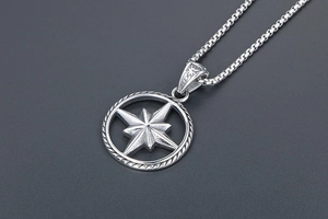 Macro view of silver octagonal star compass pendant with rope texture and mesh chain
