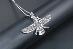 Detailed view of silver Faravahar pendant with intricate wings on a dark stand