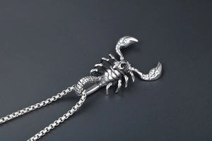 Macro detail of punk scorpion pendant with vintage silver finish and square link chain