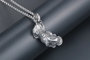 Macro shot of vintage titanium steel Pixiu pendant with detailed lucky coin carvings