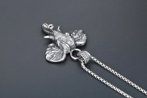 Close-up of vintage silver elephant head pendant with detailed skin texture and chain