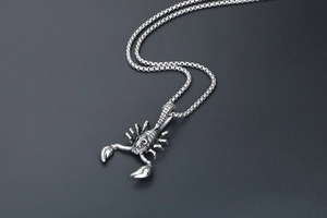 Detailed view of scorpion pendant with red rhinestone eyes and vintage silver finish