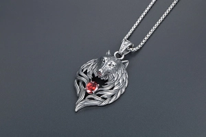 Detailed wolf head pendant in silver titanium steel with a faceted red zircon stone