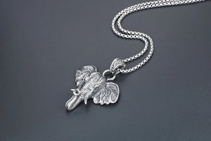 Detailed view of vintage elephant head pendant with textured skin and box chain
