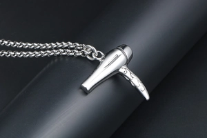 Vue macro détaillée du pendentif sèche-cheveux argenté avec gravure florale ciselée