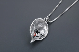 Detail of silver wolf pendant back with hollow craftsmanship and red zircon stone inlay