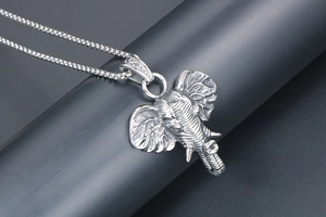 Detailed macro view of vintage silver elephant head pendant with intricate engraved textures