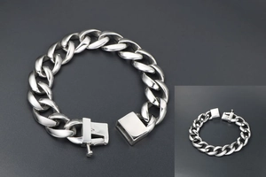 Macro detail of silver titanium steel curb chain bracelet with secure box clasp mechanism