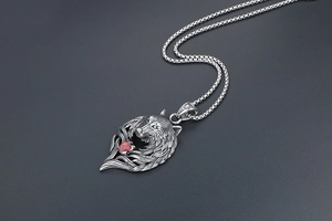 Detailed view of silver wolf head pendant with red zircon eye and textured metal fur