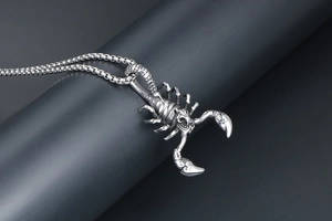 Macro shot of titanium steel scorpion pendant with detailed vintage silver carving