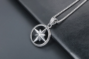 Macro shot of silver compass star pendant on box chain with polished metal finish
