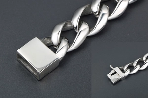 Macro view of silver curb chain bracelet with a thick square clasp and polished finish
