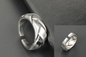 Detail macro view of retro woven leaf texture on adjustable stainless steel ring