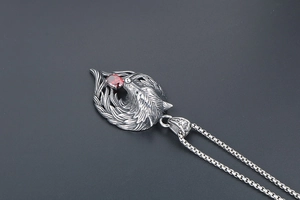 Macro shot of retro wolf head pendant in silver finish with vibrant red zircon stone inlay