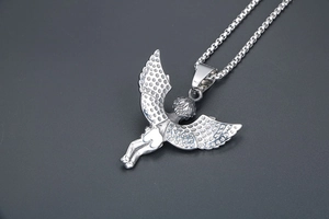 Detail showing the intricate dot texture and polished back of the silver angel pendant