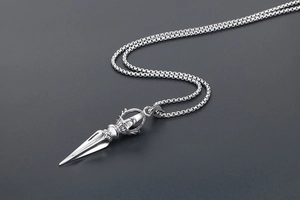 Macro shot of silver titanium steel vajra pendant with intricate relief and box chain