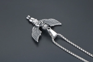 Macro detail of silver angel pendant necklace with vintage texture on box chain