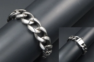 Close-up of polished silver Cuban link chain bracelet with a square box clasp detail