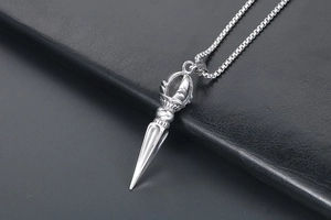 Close-up of silver titanium steel Vajra pestle pendant with textured leather background