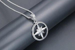 Close-up of a silver compass star pendant with twisted rope border on a Venetian chain