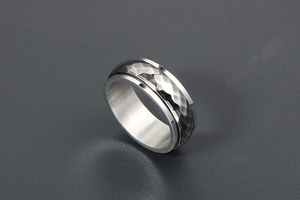 Macro shot of silver and gunmetal spinner ring with hammered texture and dual-tone finish